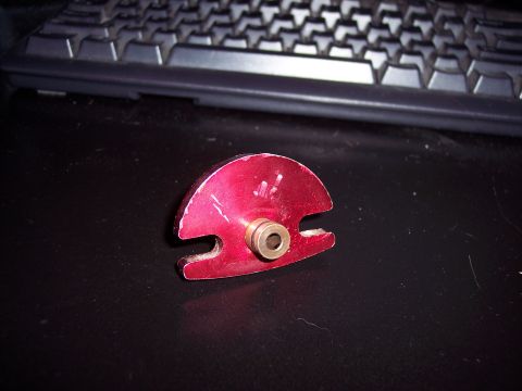 1995 Ford Probe - This red metal automotive part has a brass fitting and is shown on a dark surface.