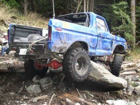 1979 Ford Bronco - This blue Ford Bronco is tackling a challenging rocky terrain, its off-road capabilities.