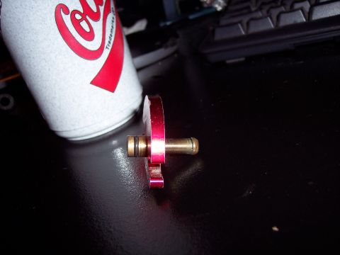 1995 Ford Probe - A red metal fuel rail adapter with brass fittings is shown next to a Coca-Cola can.