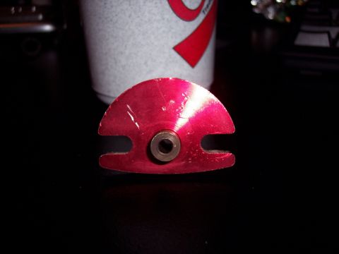 1995 Ford Probe - A close-up of a red automotive part is shown against a dark background with a cup nearby.