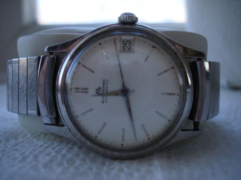 1994 Ford Bronco - A close-up view of a watch with a white face and metal band.