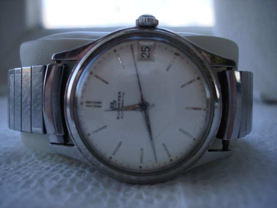 Watch with white face, date window, and metal band