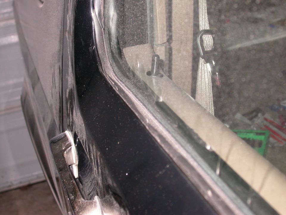 Interior door panel and window trim with visible clip and seatbelt anchor