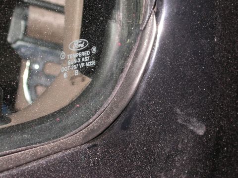 1996 Ford Bronco - Close-up of a vehicle's door frame and tempered glass, revealing manufacturer markings.