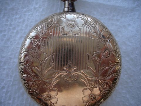 1994 Ford Bronco - This gold pocket watch features detailed floral patterns and a textured surface, with a watermark at the bottom right.