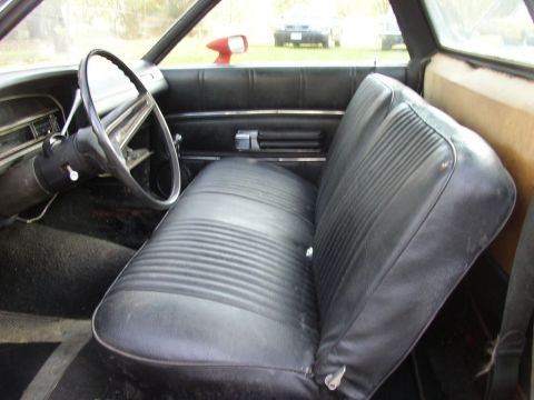 1990 Ford F-250 - The interior of this vintage truck features a black vinyl bench seat and a dashboard with a prominent steering wheel.