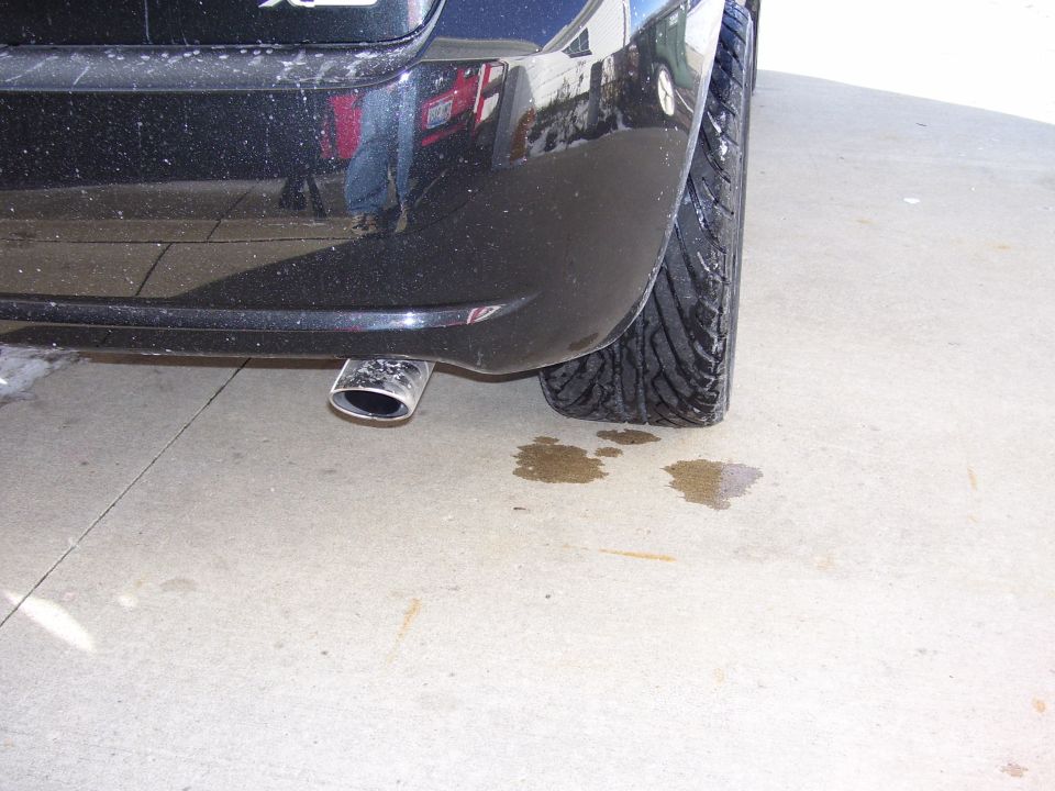 Chrome angle-cut exhaust tip under the rear bumper of a black hatchback