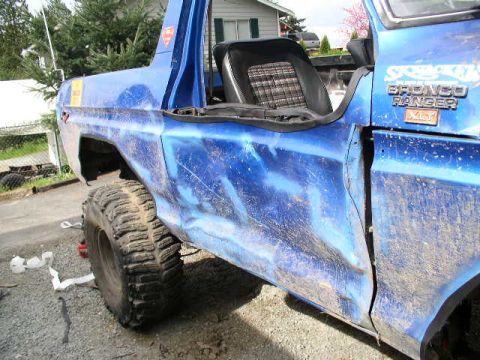 1979 Ford Bronco - This blue Ford Bronco Ranger shows significant body damage and custom paintwork.