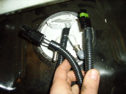 1991 Ford Bronco - Fuel pump assembly with electrical connectors and hoses removed from a fuel tank.