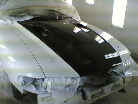 1997 Ford Mustang - A white car with a black hood is being worked on, with protective coverings visible.