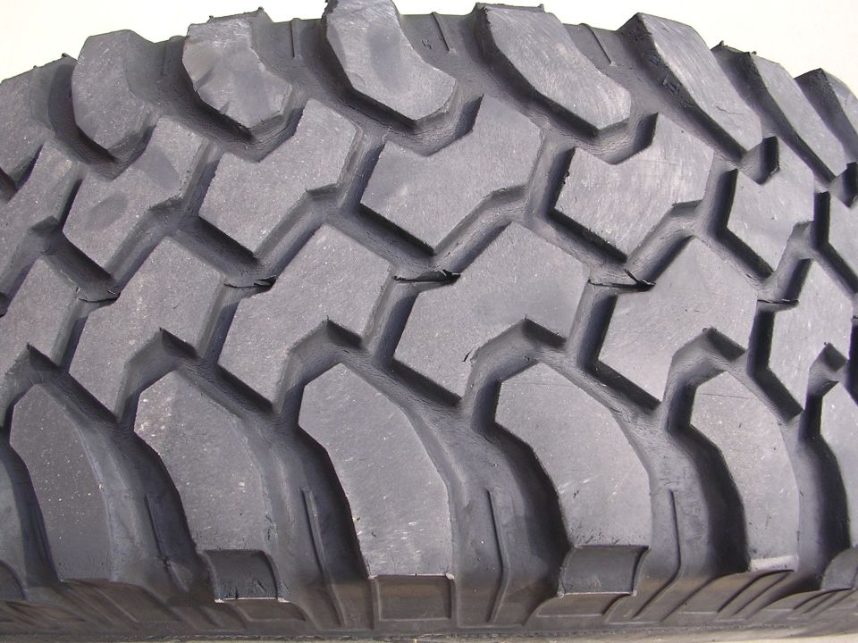 Tire tread with deep, aggressive lugs and sipes. The rubber shows some minor cracking