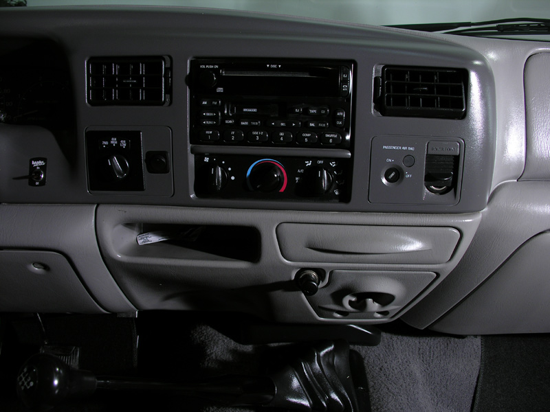 Gray Ford truck interior dash with radio, climate controls, vents and shift levers