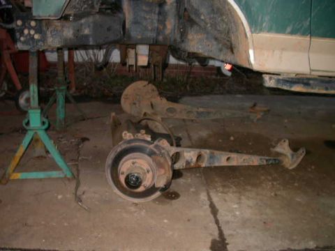 1990 Ford Bronco - Ford Bronco suspension components are visible while the vehicle is supported by jack stands.