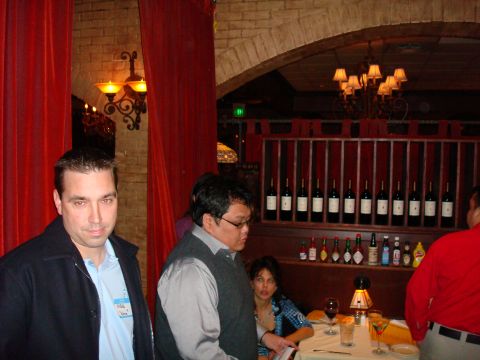 1990 Ford Bronco - A group of people are seen inside a restaurant, with a display of wine bottles in the background.