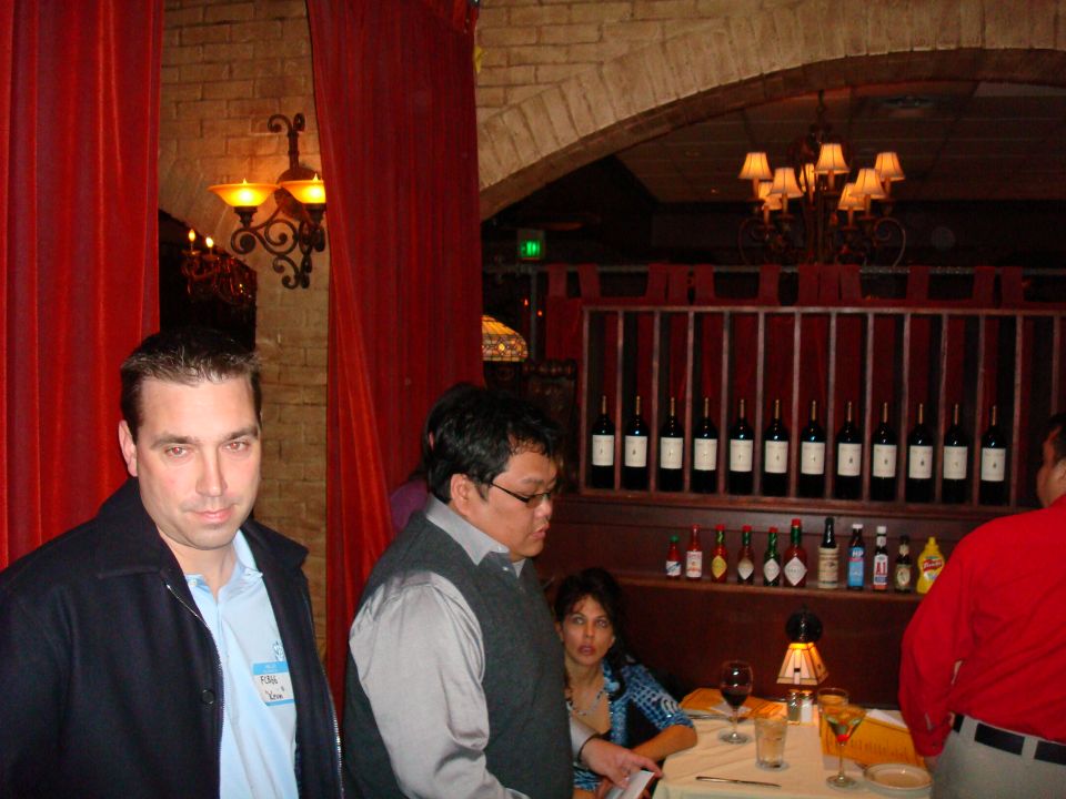 People gathered inside a restaurant with wine bottles on display