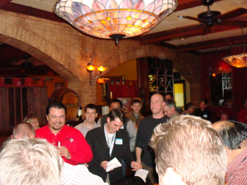 People gathered indoors under a stained-glass lamp