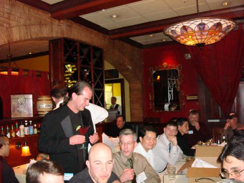 1990 Ford Bronco - A group of men are seated at tables in a dimly lit restaurant, some holding drinks.