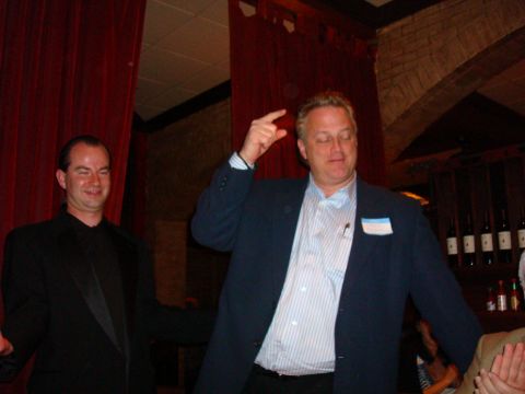 1990 Ford Bronco - Two men in suits are seen at an indoor event, with one man making a gesture with his hand.