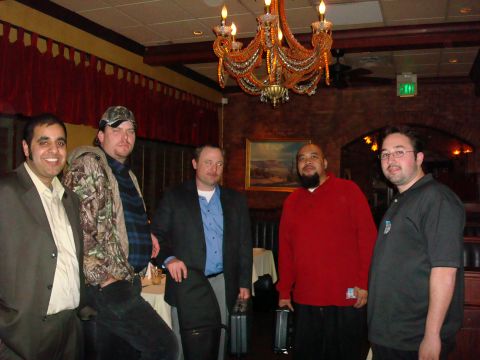1990 Ford Bronco - Five men stand together in a room with a decorative chandelier and artwork on the walls.