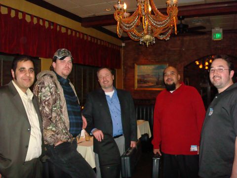 1990 Ford Bronco - A group of men gathered indoors, possibly at a restaurant, with a decorative chandelier overhead.