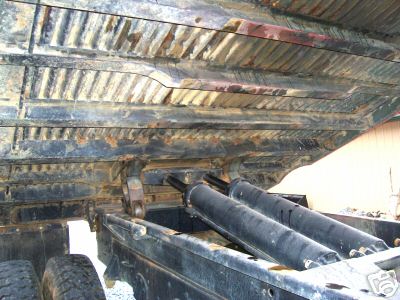 1968 Jeep CJ5 - The underside of a dump truck bed shows its ribbed structure and hydraulic lift cylinders.