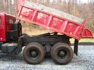 1968 Jeep CJ5 - The rear section of a red dump truck is shown with its bed in the raised position.