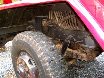 1968 Jeep CJ5 - Close-up view of the front wheel well and suspension of a red 1968 Jeep CJ5.