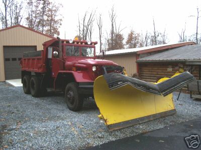 1968 Jeep CJ5 - Dump truck equipped with a snow plow sits idle near outbuildings.