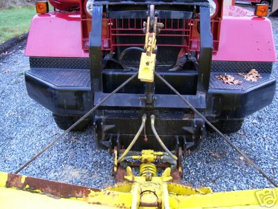 1968 Jeep CJ5 - A red Jeep is equipped with a yellow snow plow attachment, viewed from the front.