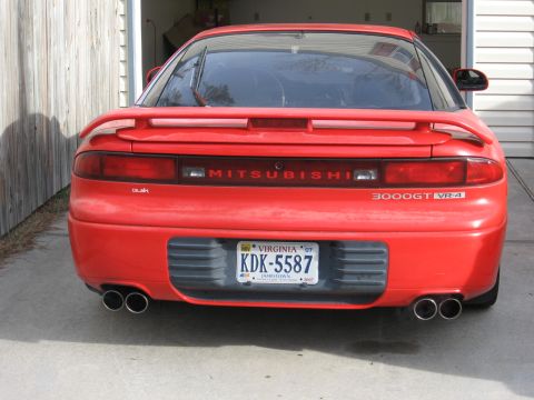 1991 Mitsubishi 3000GT - The rear of a red 1991 Mitsubishi 3000GT VR-4 is shown, dual exhaust pipes and a Virginia license plate.