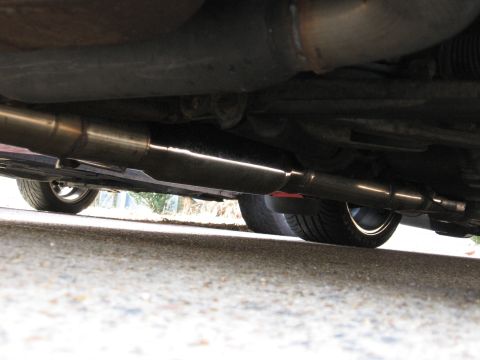 1991 Mitsubishi 3000GT - The underside of a vehicle is visible, showing the exhaust system and a portion of the rear wheel.
