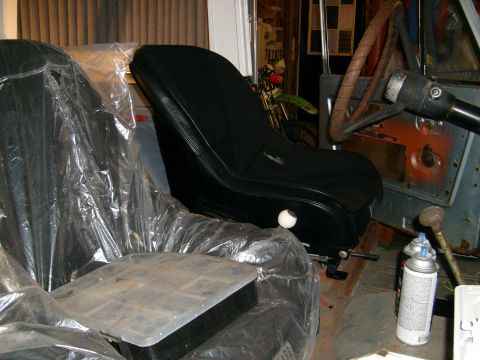 1974 Ford Bronco - Interior view of a car, showing a black racing seat and a plastic-covered seat.