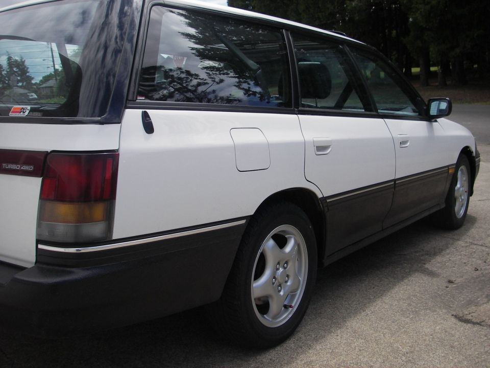 White Subaru Legacy wagon rear quarter with TURBO 4WD badge and alloy wheel