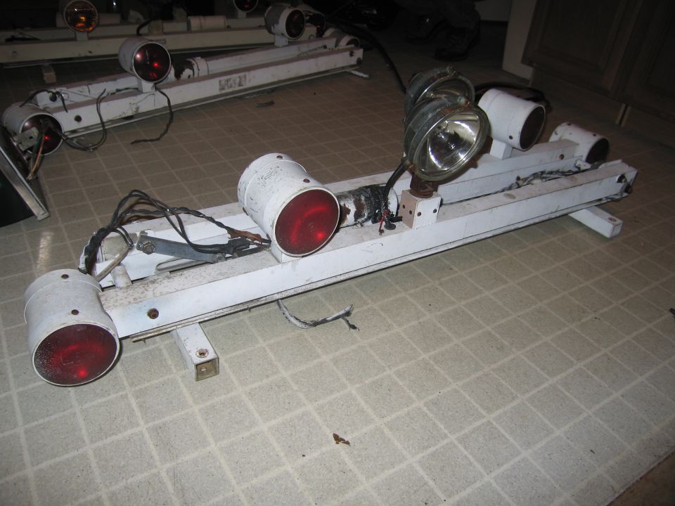White police light bar with red and clear lights, chrome spotlight, and wiring