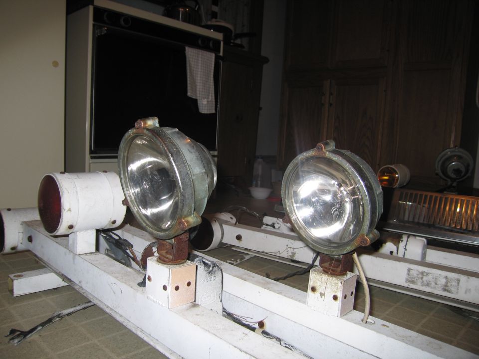 Police car light bar with two large spotlights and a red light