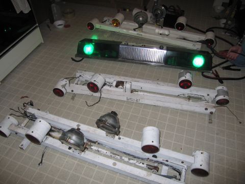 1991 Ford LTD Crown Victoria - Multiple police light bars are laid out on the floor, some with green and red lights illuminated.