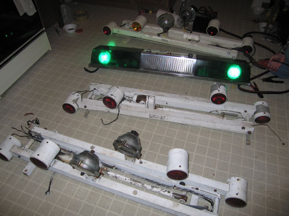 Several police light bars with green and red lights, some with chrome grilles