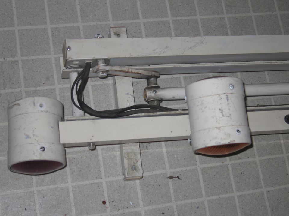 Close-up of a white light fixture with two orange lenses, mounted on a wall
