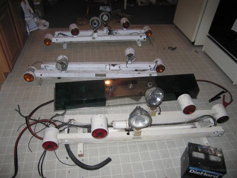 1991 Ford LTD Crown Victoria - Collection of police light bars, some with red and amber lenses, are laid out on a tiled floor.