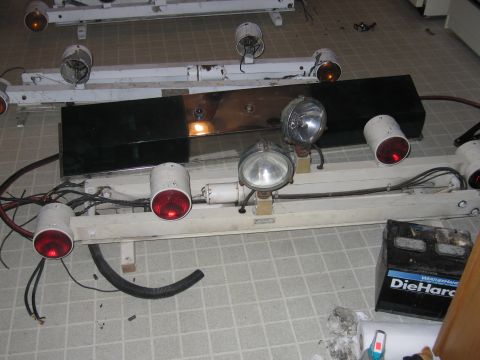 1991 Ford LTD Crown Victoria - Close-up of a police light bar assembly, including various lights and associated wiring, next to a DieHard battery.