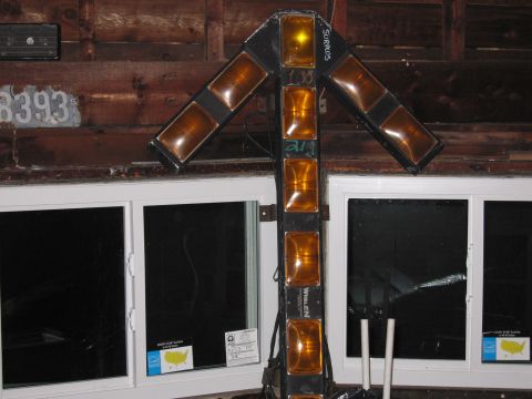1991 Ford LTD Crown Victoria - A directional arrow light bar with multiple amber lights is shown mounted against a wooden wall above two windows.
