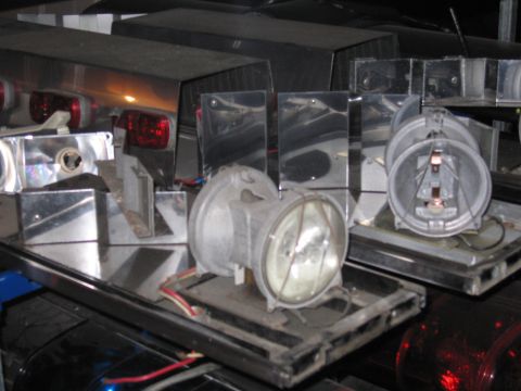 1991 Ford LTD Crown Victoria - Various parts of a police light bar are laid out, showing headlights and red taillights.