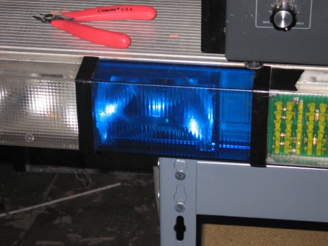 1991 Ford LTD Crown Victoria - Wire cutters rest on a shelf above components of an emergency light bar.