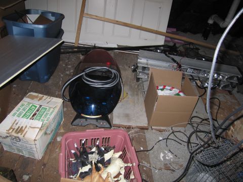 1991 Ford LTD Crown Victoria - A collection of items, including a police light bar and toy horses, are stored in a cluttered room.