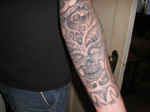 1995 Ford Bronco - Close-up of a grey ink skull tattoo on a person's arm.
