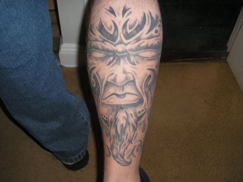 1995 Ford Bronco - A close-up of a tribal face tattoo with a beard on a person's leg.