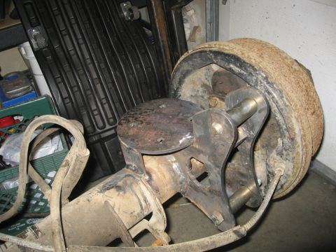 1990 Ford F-250 - This photo shows a close-up of a vehicle's axle and brake drum assembly, likely in a garage or workshop setting.