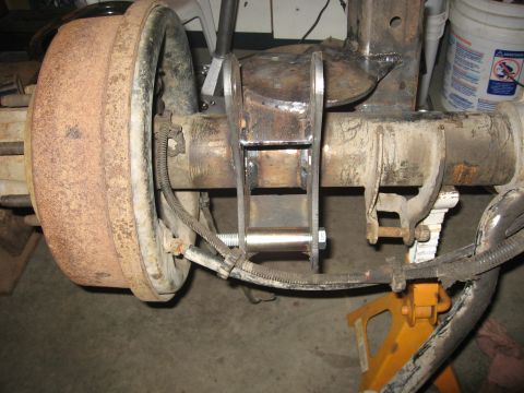 1990 Ford F-250 - Close-up of a vehicle's rear axle assembly, showing a brake drum and a newly welded bracket.