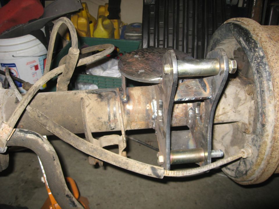 Rear axle assembly with custom bracketry and brake drum