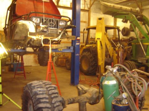 1992 Ford Bronco - Garage scene with a Jeep on a lift, plus a backhoe and tractor.
